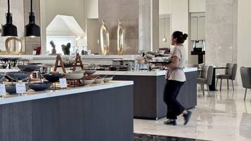 A modern kitchen with a central island, stainless steel appliances, and a variety of cookware displayed on the counter.