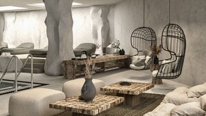 Un interior moderno con pared de piedra, un banco de madera, una silla colgante y una mesa de centro.