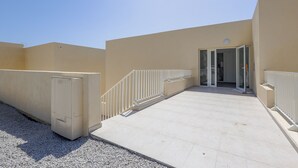 A building with a beige exterior, a white door, and a white railing.