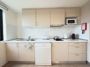 A compact kitchen with a microwave, toaster, kettle, and dishwasher. - LEGACY SUITES & APARTMENTS ALBUFEIRA AL (Albufeira)