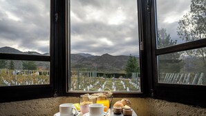 A table with breakfast items and a view of a cemetery through a window.