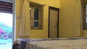 Una habitación con una cama, una puerta y una ventana.