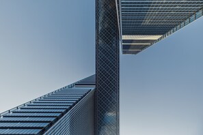 A tall building with a modern architectural design, featuring a prominent glass facade and a unique diagonal structure.