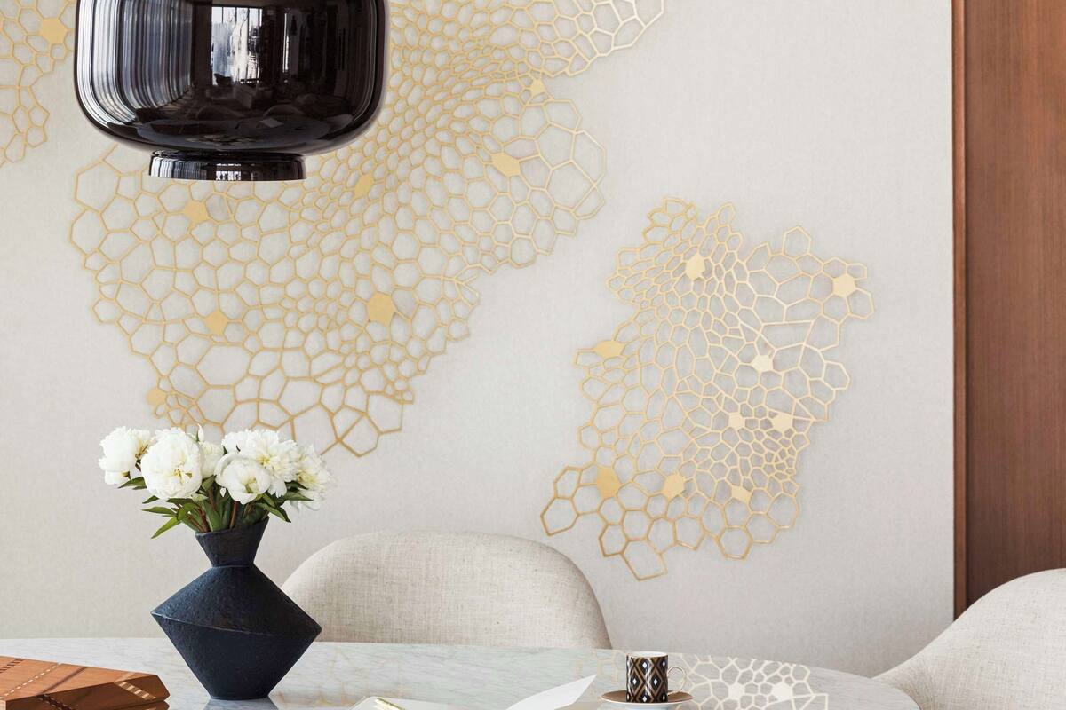 Un intérieur moderne avec une table ronde, un vase de fleurs et une œuvre d’art murale.