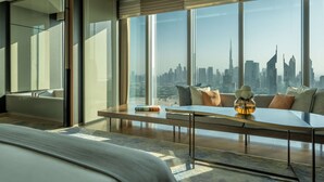 A modern hotel room with a large window offering a city skyline view. - One&Only One Za'abeel (Dubai)