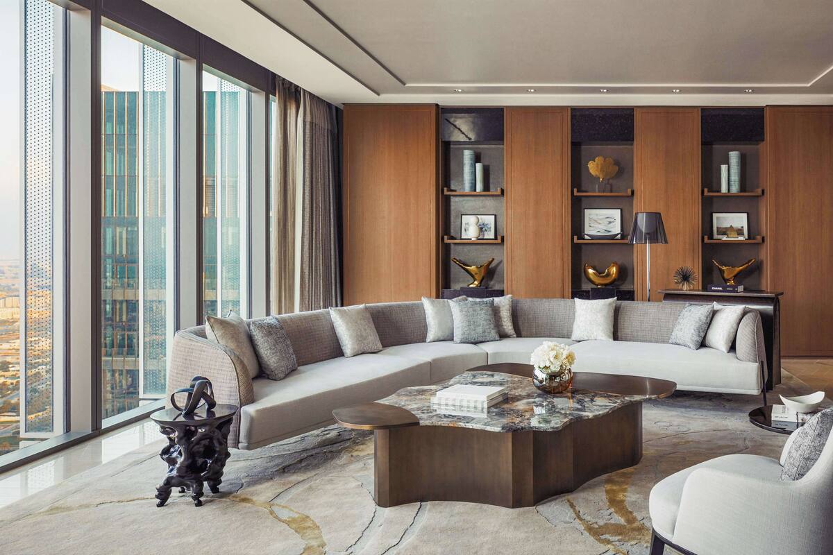 Un salon moderne avec un grand canapé d’angle, une table basse et une bibliothèque.