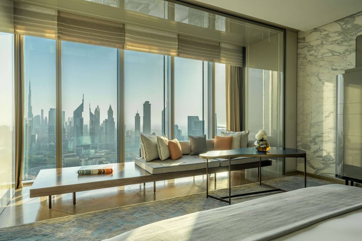 Une chambre moderne avec vue sur la ville, comprenant un canapé, une table et une grande fenêtre.