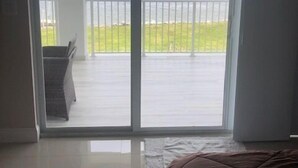 A room with a large sliding glass door leading to a balcony with a view of the sea. - Breathtaking sunrises from your balcony at this 3 bedroom, 2 bath home (Big Pine Key)