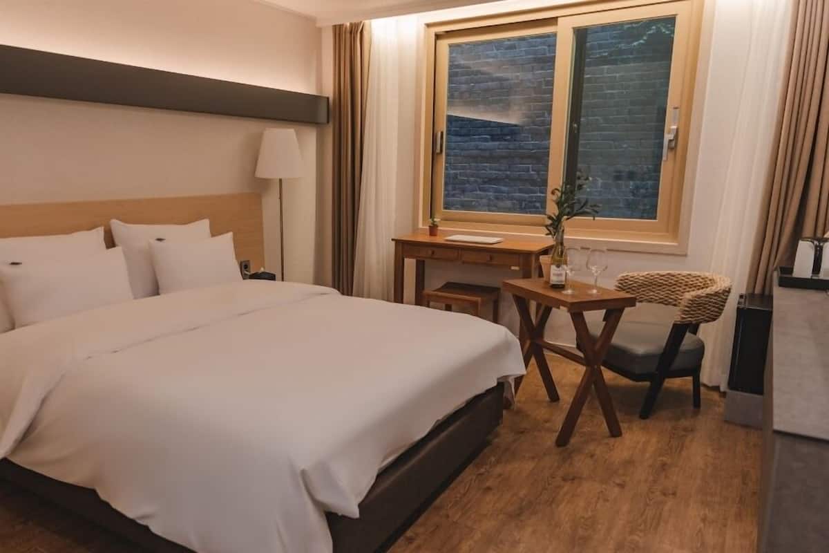 Ein Hotelzimmer mit einem großen Bett, einem Schreibtisch und einem Sessel.