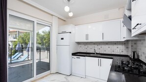 Et moderne køkken med hvide skabe, en sort bordplade og en gaskomfur.