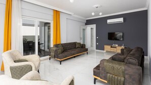 Un salon moderne avec un ensemble de canapés, un téléviseur et un meuble en bois.