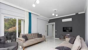 A modern living room with a sofa, armchairs, and a TV. - Villa Sasha 3 - Four Bedroom Villa, Sleeps 10 (Ortaca)