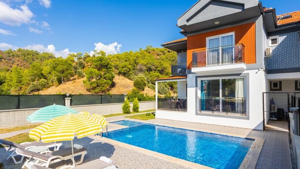 A modern two-story house with a swimming pool, outdoor seating, and a view of a hillside. - Villa Sasha 3 - Four Bedroom Villa, Sleeps 10 (Ortaca)