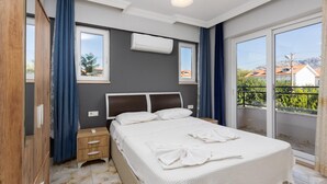 Un dormitorio con cama, mesita de noche y vistas al exterior.