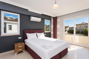 Un dormitorio con cama, mesita de noche, aire acondicionado y vista al exterior.