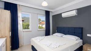 A bedroom with a bed, a window, an air conditioning unit, and a wooden wardrobe. - Villa Kaya 2 - Five Bedroom Villa, Sleeps 12 (Dalyan)