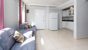 A modern apartment with a grey sofa set, a white refrigerator, and a kitchen area with white cabinets. - Villa Kaya 2 - Five Bedroom Villa, Sleeps 12 (Dalyan)