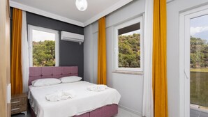 A bedroom with a bed, a window with curtains, a ceiling light, and a view of trees. - Villa Sasha 2 - Four Bedroom Villa, Sleeps 10 (Ortaca)