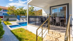 A modern outdoor patio with a pool, lounge chairs, and a dining area with tables and chairs. - Villa Sasha 2 - Four Bedroom Villa, Sleeps 10 (Ortaca)