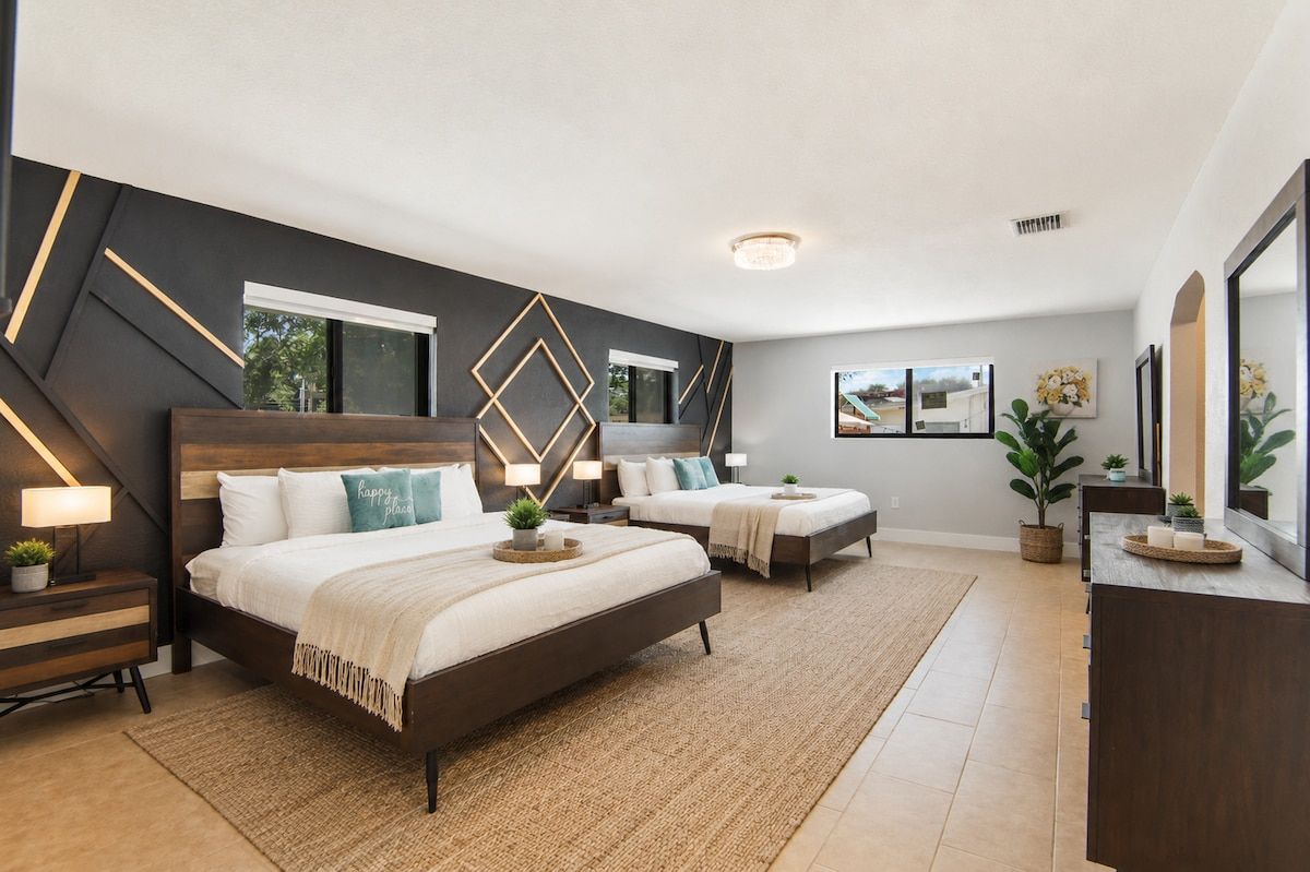 A modern bedroom with two beds, a large window, and a view of the outdoors.