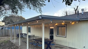 A covered patio area with a table and chairs, a door, and a window. - Round Rock Supernova minutes from Kalahari, Round Rock Sports Complex, and DT  (Round Rock)