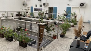 A multi-level indoor space with potted plants, metal railings, and air conditioning units. - Aleksei apartments (Belgrade)