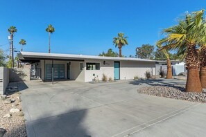 A modern single-story house with a flat roof, a garage, and a driveway. - Poolside at Panorama - Walk to El Paseo (Palm Desert)
