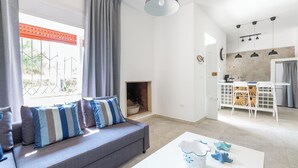 A modern living room with a grey sofa, striped cushions, a white coffee table, and a fireplace.