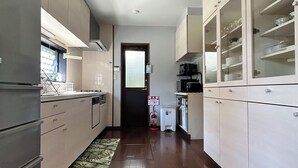 Una cocina moderna con suelo de madera, electrodomésticos de acero inoxidable y una isla central.
