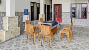 Ein Patio mit Tisch, Stühlen, einem Wasserspender und einer Tür.
