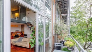 A modern interior with a sofa, coffee table, and staircase leading to an upper level. - Incredible 2BD Loft by Regents Canal - Haggerston (London)