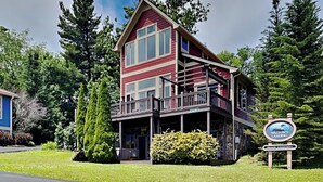 A two-story building with a balcony, surrounded by greenery. - At the Start of It All by Taylor Made Deep Creek (McHenry)