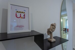 A framed picture with a cartoon character and text, and a sculpture on a black shelf.