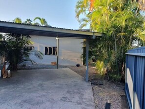 Enjoy the serene atmosphere of this outdoor space, surrounded by lush vegetation and a standalone building.