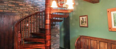 Una escalera en espiral de madera con un banco en la parte inferior.