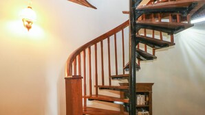 Eine Holztreppe mit schwarzer Handläufe, die zu einer Aussichtsplattform führt.