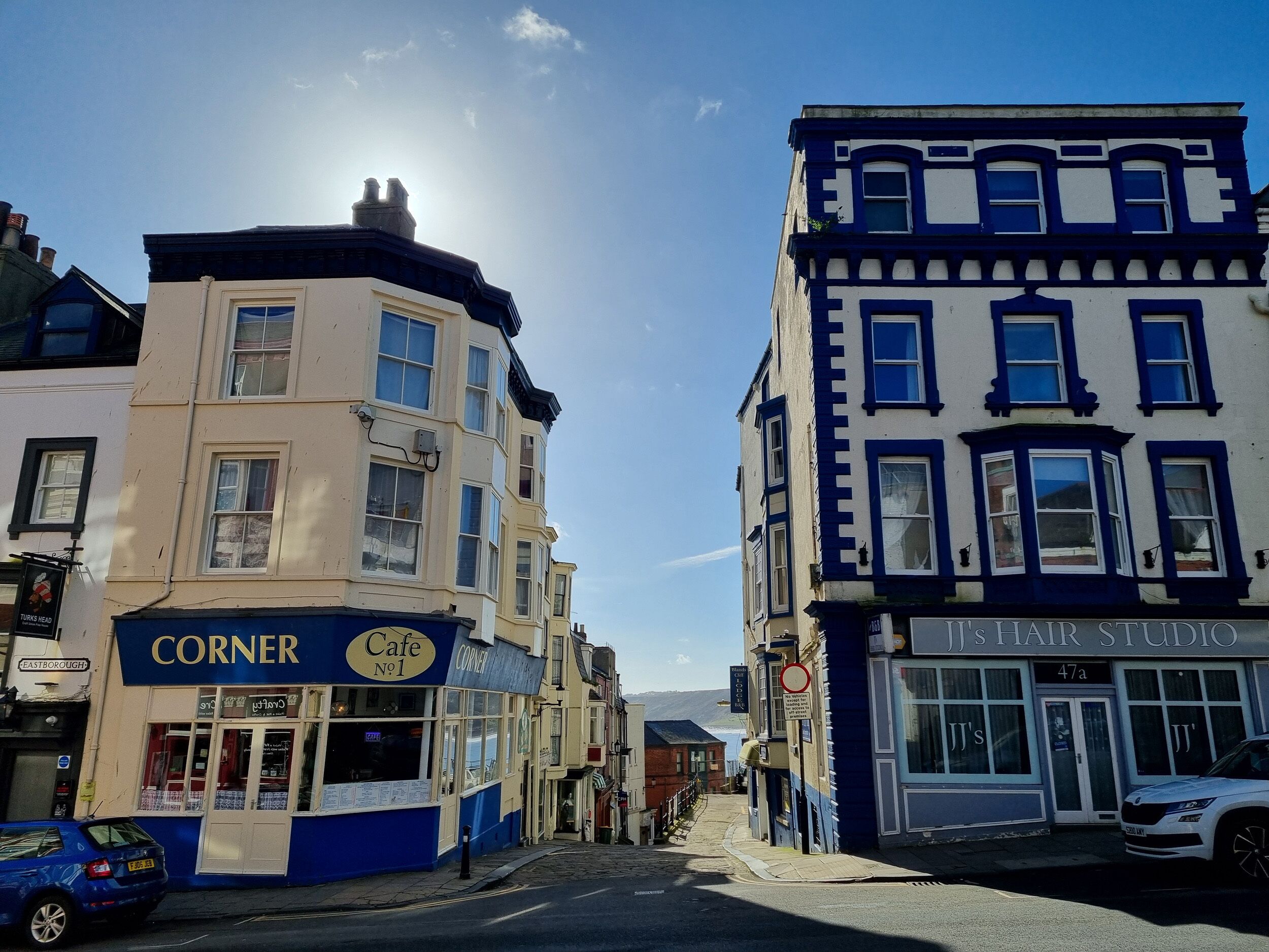 A street view with buildings labeled 'Corner Cafe No.1' and 'JJ's Hair Studio'.