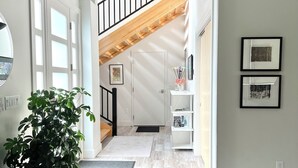 A modern interior with a staircase, white walls, and a ceiling with exposed beams and ductwork. - Luxury Creekside Condo , steps away from shopping & dining (Traverse City)