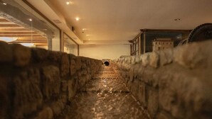 A narrow stone corridor with a view of a building in the distance. - Arbizu (Arbizu)