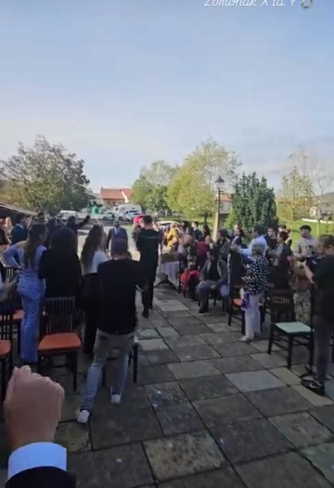 An outdoor gathering with people seated on chairs arranged in rows, facing a central point.