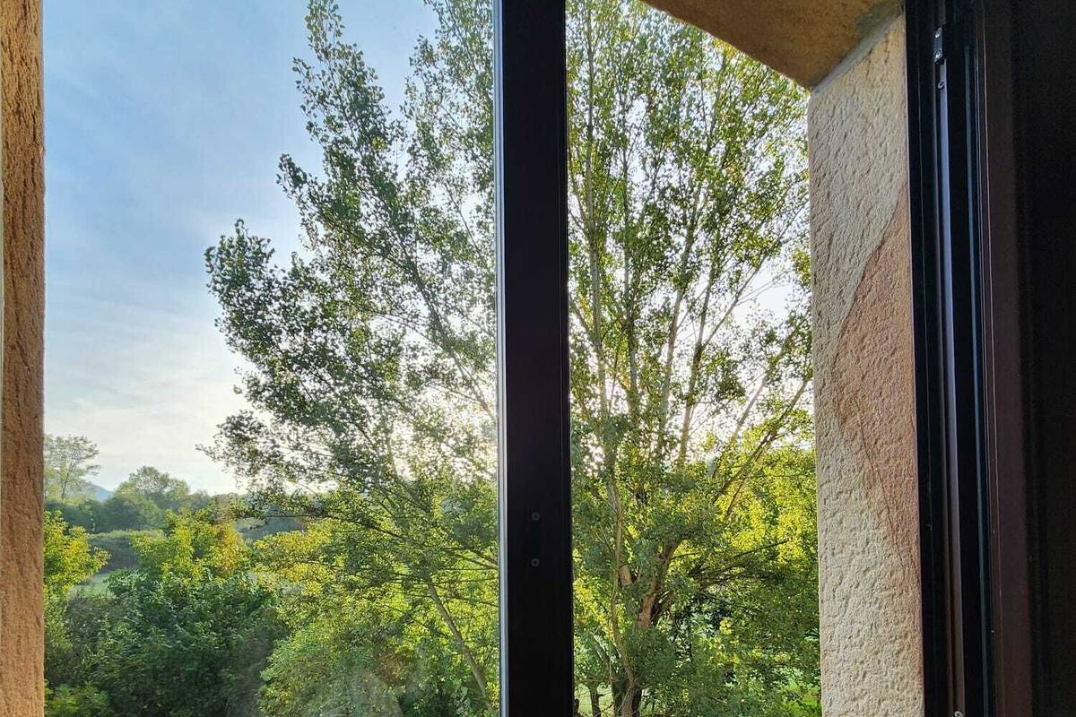 Una habitación con un ventanal grande que da a un área boscosa.