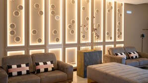 A modern living room with two sofas, a coffee table, and a decorative wall with illuminated floral patterns. - Palacio Santa Catarina Hotel (Angra do Heroismo)
