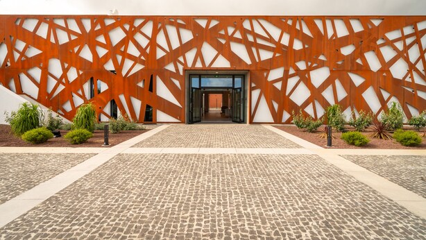A building entrance with a geometric facade and a cobblestone pathway leading to it. - Palacio Santa Catarina Hotel (Angra do Heroismo)