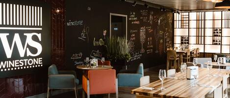 L’intérieur d’un restaurant avec un menu écrit à la craie, des tables et des chaises en bois.