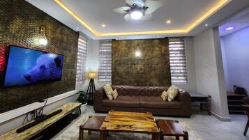 Una Smart TV, libros, un reproductor estéreo, una pantalla de ordenador