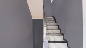 A staircase with a modern design, featuring a straight flight of steps and a handrail on the right side. - Hotel O Surabaya near Universitas Airlangga formerly Kertajaya Residence Surabaya (Surabaya)