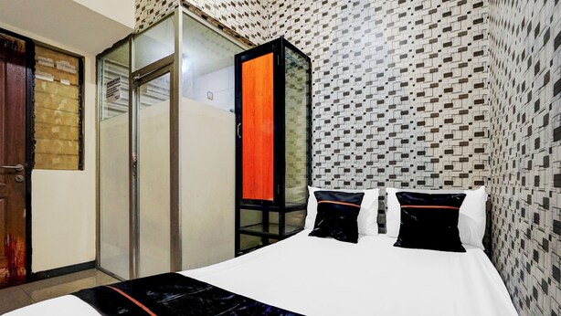 A hotel room with a bed, a wardrobe, and a mirror. - Hotel O Surabaya near Universitas Airlangga formerly Kertajaya Residence Surabaya (Surabaya)