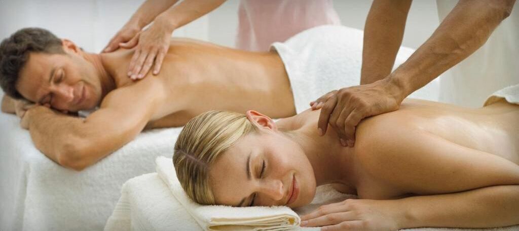 Een massagesessie in een spa met een witte handdoek en een massagetafel.