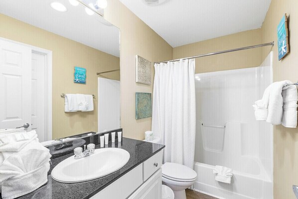 A bathroom with a sink, toilet, and shower.