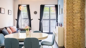 A cozy dining area with a round table, chairs, and a vase of flowers.